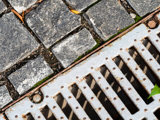 top view of stone paving and old street drain grate in Moscow city