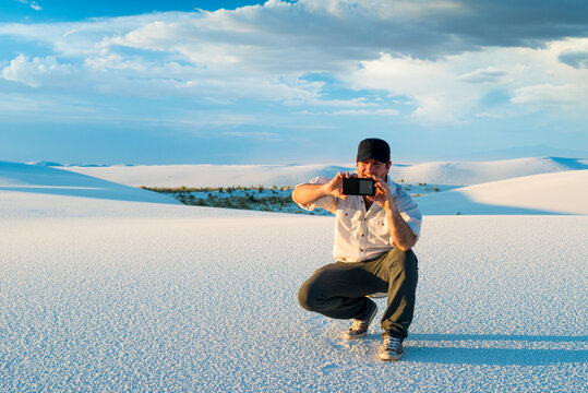 Man Taking Picture WIth Mobile Phone of White Sand Dunes with in White Sands National Monument New Mexico
