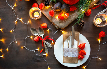 Festive table setting with pumpkin, autumn leaves and seasonal autumn decor. Autumn style table setting with garland. Copy space.