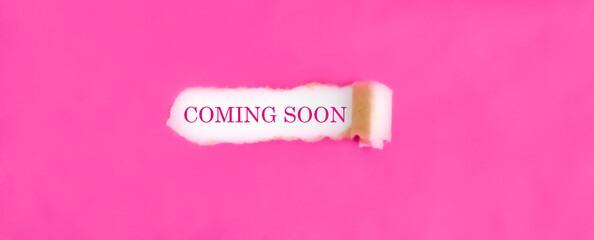 The text COMING SOON appearing behind torn pink paper.