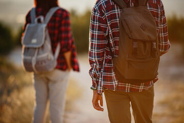 Portrait of happy young couple having fun on their hiking trip. Caucasian and asian hiker couple enjoying themselves on summer vacation.