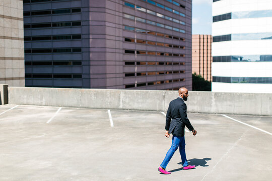 An African American man walking in business attire outdoors in the city