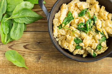 scrambled eggs with spinach in a cast-iron pan.
