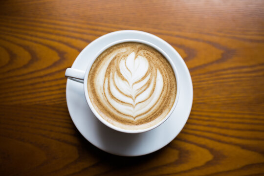 Latte with rosetta pattern on a wood counter