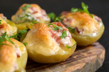 Hot baked stuffed potatoes with cheese, bacon, parsley.
