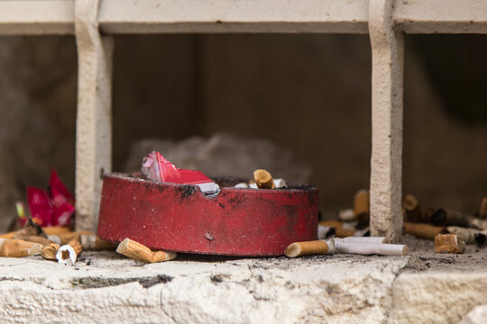 Overflowing ashtray in a window niche
