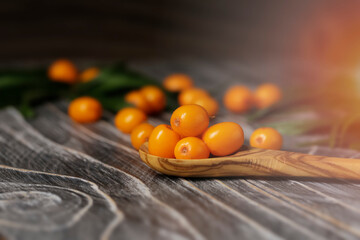 Fototapeta na wymiar Sea buckthorn on wooden black background. Top view, place for your text.