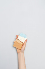 Woman holding natural handmade soap bar on white cloth background