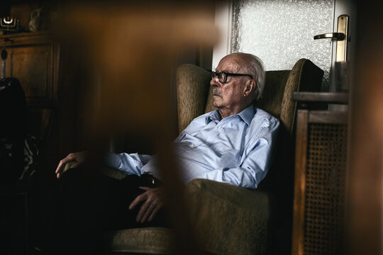 A 96 years old man. Grandfather sitting on a couch at home.