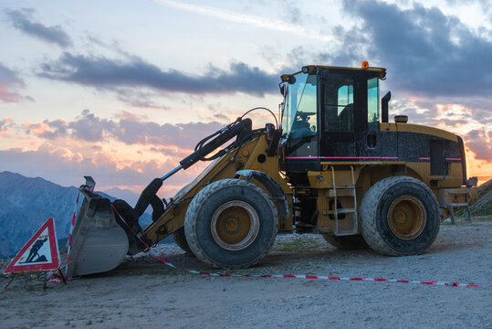 Bulldozer and men at work sign after working day outdoor