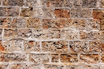 A wall formed by spongy textured bricks attached with cement solution