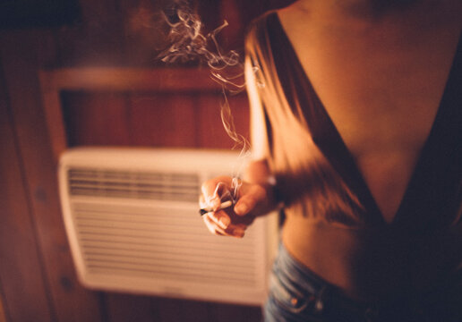 A young woman smoking indoors