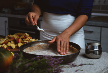 Preparation, Thanksgiving Celebration. The cook prepares to pour sugar from a silver spoon onto the dough for the apple pie.