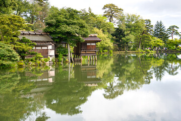 建物と木と雲の湖による反射