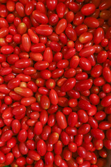 Lots of red tomatoes at bazaar. agriculture farm full of organic vegetables. Pile of ripe tasty red tomatoes in the store. Top view of tomatoes Lycopersicon esculentum Mill (selective focus)