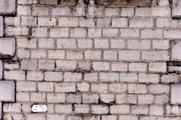 A wall made up of grey bricks and an ancient look with black color splashes