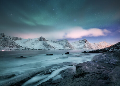 Aurora borealis on Lofoten islands, Norway. Green northern lights above mountains. Night winter landscape with aurora. Natural background in the Norway.