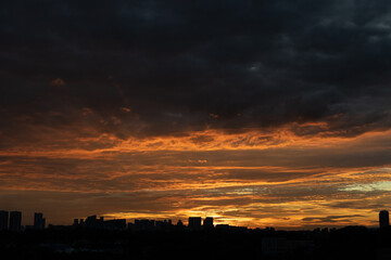 Warm sunset over city skyline with tall buildings in the foreground