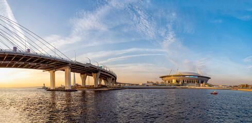 Panoramic view of Zenith arena football stadium, cable-stayed bridge and highway at sunset.