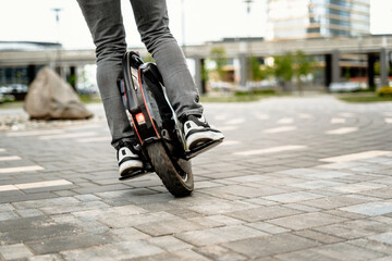 Man riding electric mono cycle on street - obrazy, fototapety, plakaty