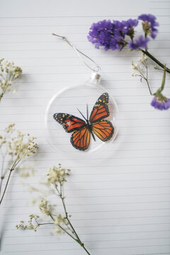 Beautiful faux butterfly in Christmas baubles on notebook
