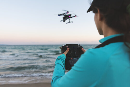 Active woman using a drone on the beach