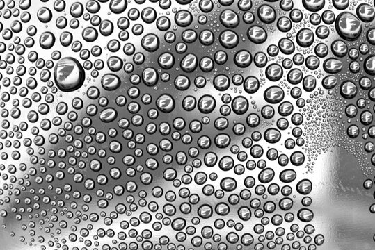 Closeup macrophotograph macro of water droplets condensed on a clear curved surface