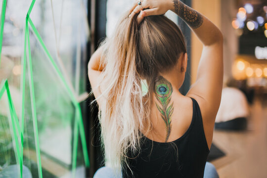 Girl with a peacock feather tattoo