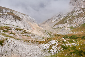 rocky alpine gorge partially obscured by a cloud