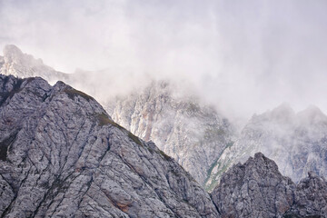 sharp rocky mountain peaks lurk in the clouds