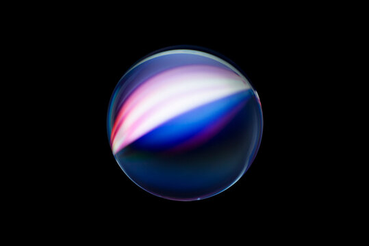 Blurry image of a shiny crystal ball with abstract blurry colorful pattern. Abstract lensball in blur.