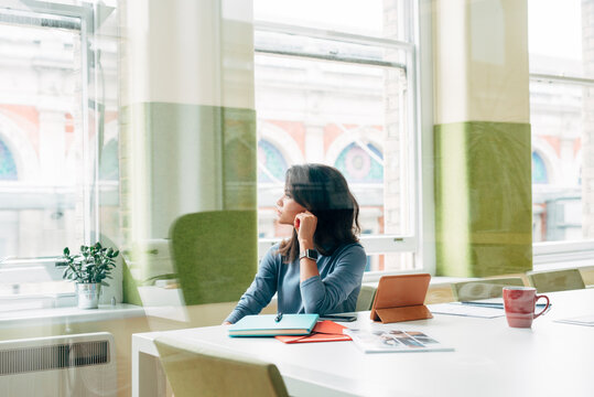 Businesswoman thinking looking out of the window at work