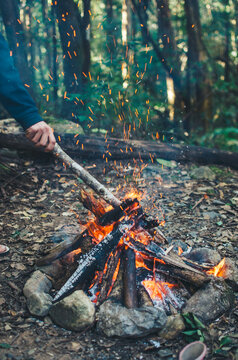 Man stoking camp fire