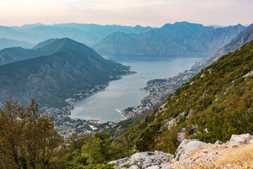 Panorama of Kotor bay and city from mountain road. Beautiful view to Kotor city with lovely architecture, hotwls and boats in the sea.