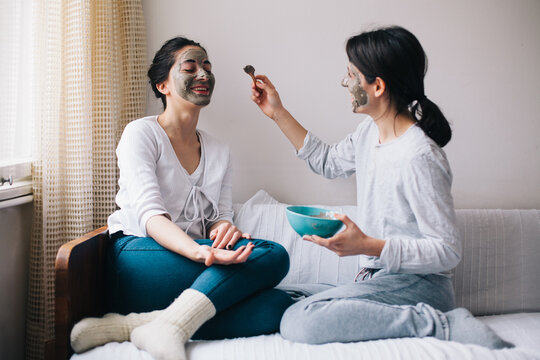 Two female friends having beauty treatment in their home