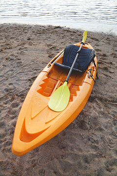 Yellow kayaks sit on a beach at sunset after a day paddling