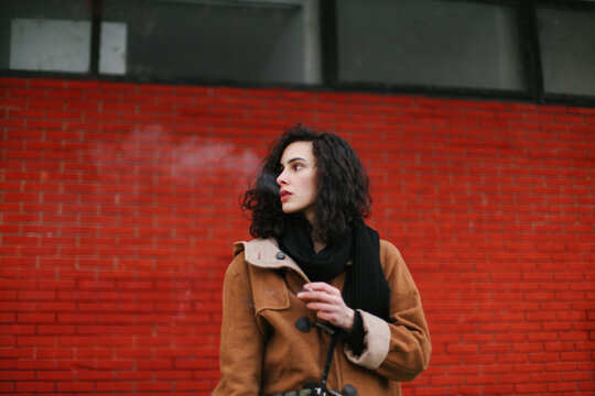 Brunette woman smoking, red background