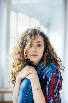 Portrait of beautiful woman with curly hair, indoors