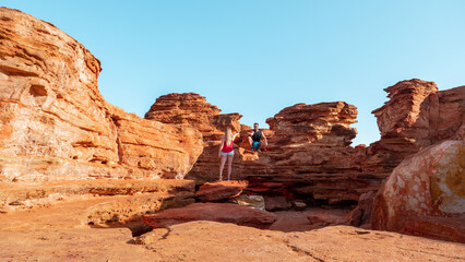 Couple hiking the red and rocky coastline of Broome in Austrlia