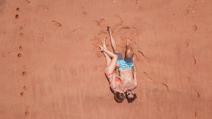 Couple lying on red sand beach