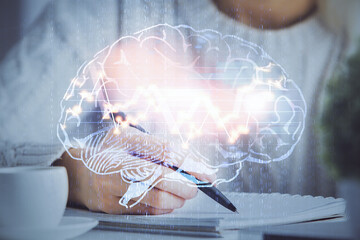 Multi exposure of writing hand on background with brain hologram. Concept of learning.