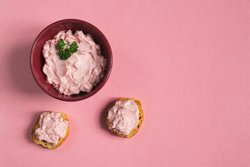 A bowl and crostini with tarama or taramasalata canape isolated on the pink background