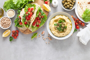 Tortilla wraps with chickpea hummus, fresh tomatoes and olives, vegan food