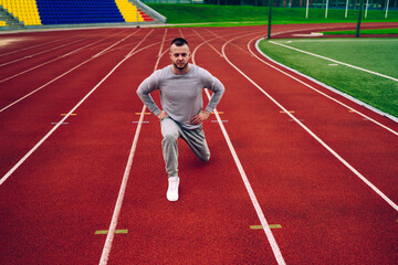 Determined ethnic athlete exercising on track