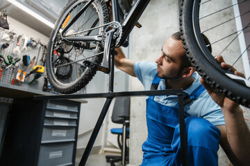 Bicycle repair, man checks the wheel for backlash