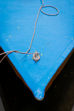 Close-up of rostrum of blue fishing boat with rope
