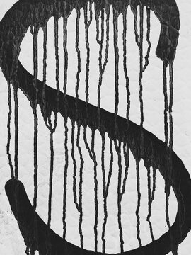 Dripping letter "S" painted on wall, close up