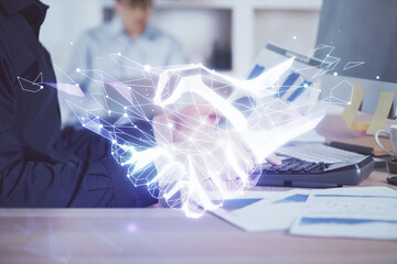 Handshake hologram drawing with businessman working on computer on background. Double exposure.