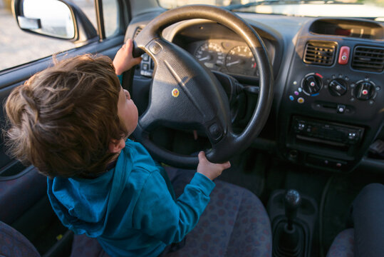 Little boy driving his father's car