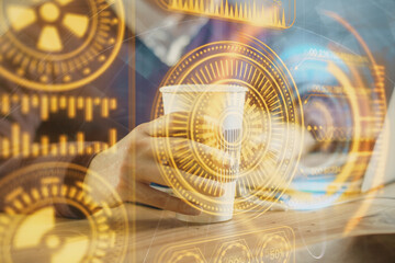 Technology theme hologram with man working on computer on background. High tech concept. Multi exposure.